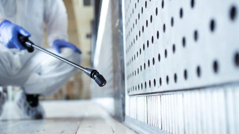 Technik wykonuje oprysk przy zabudowie kuchennej podczas dezynsekcji